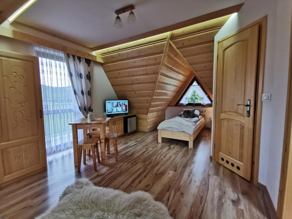 a bedroom with a bed, chair, desk and a window at Pokoje Gościnne Kurosik in Zakopane