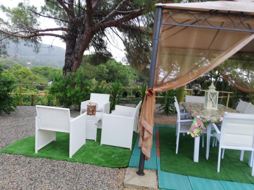 a group of white chairs and a table on grass at Lupetta in Lacona