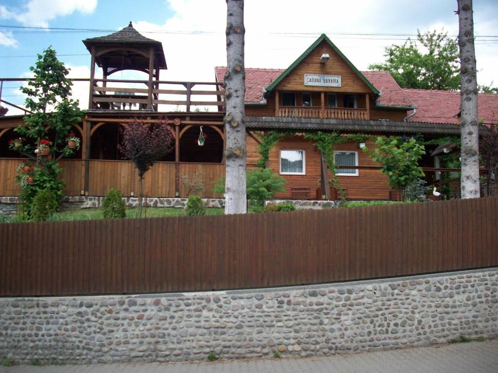 a wooden house with a fence in front of it at Cabana Bavaria in Sovata