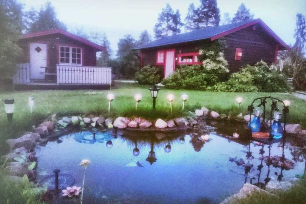 a small pond in front of a house at Cosy non smoking Cabin close to beach,Alnö in Sundsvall