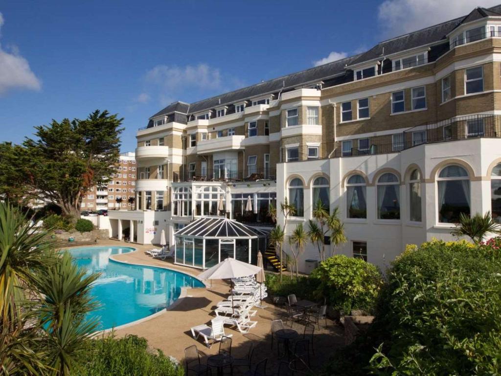 a large building with a swimming pool next to a building at Bournemouth Carlton Hotel, BW Signature Collection in Bournemouth