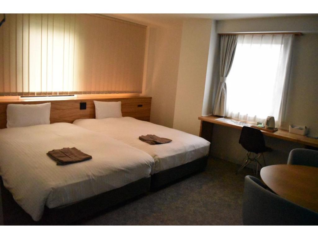 Una habitación de hotel con una cama con dos toallas. en SERENDIP HOTEL GOTO - Vacation STAY 82394, en Goto