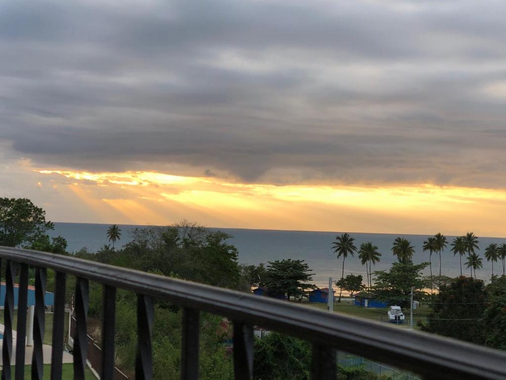 a view of the ocean from a balcony at sunset at Stunning Sunset View, Walking distance to private beach in Cabo Rojo