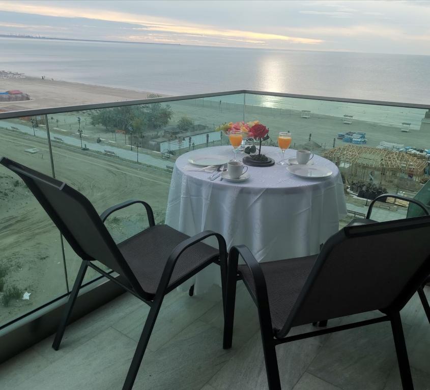 un tavolo e sedie su un balcone con vista sull'oceano di MaraVali Seaview Mamaia a Mamaia
