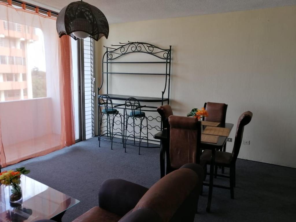 a living room with a table and chairs and a room with a table at Apartamento 1007 Cortijo Reforma zona 9 in Guatemala