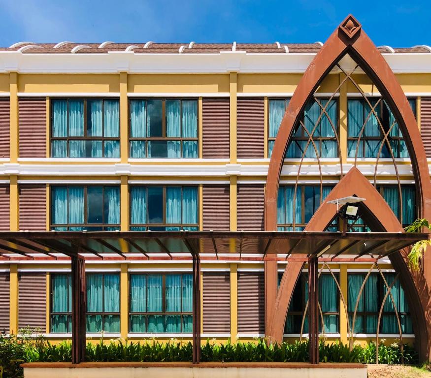 um edifício com uma grande escultura de metal à sua frente em Srilamduan Hotel em Si Sa Ket