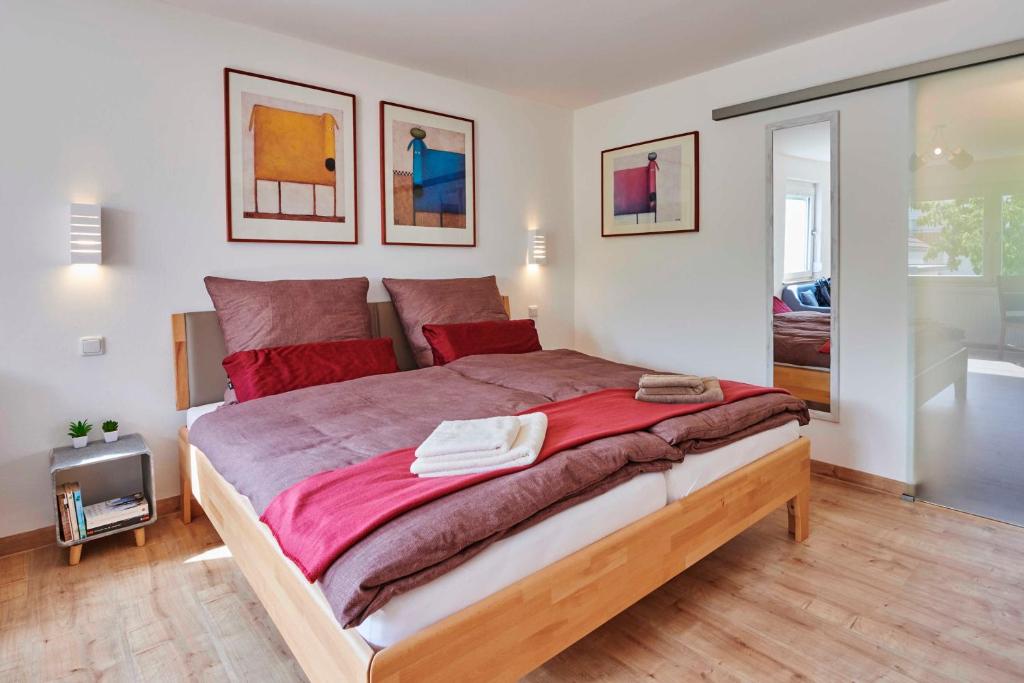 una camera da letto con un grande letto con lenzuola rosse di Ferien-Apartment Beller a Strullendorf