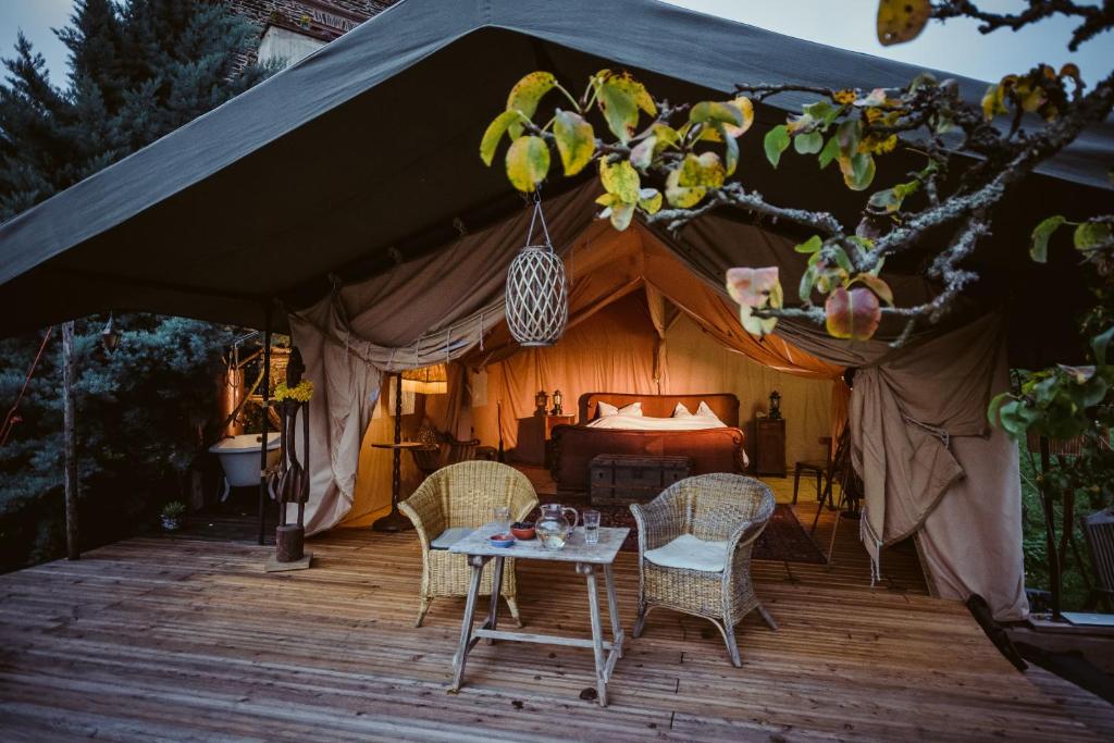 Tienda de campaña con cama y sillas en una terraza de madera en Moselglamping en Traben-Trarbach