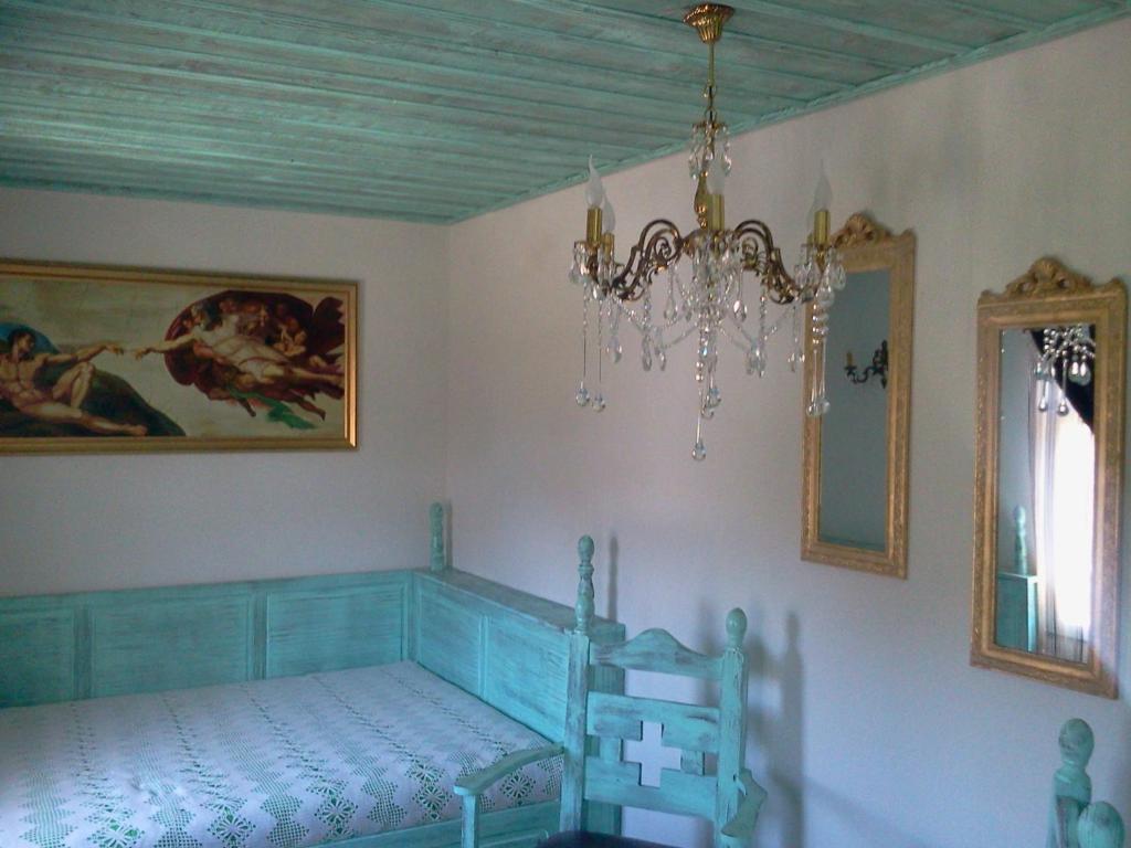 a bedroom with a bed and a chandelier at Kashtata s Paraklisa in Borowo