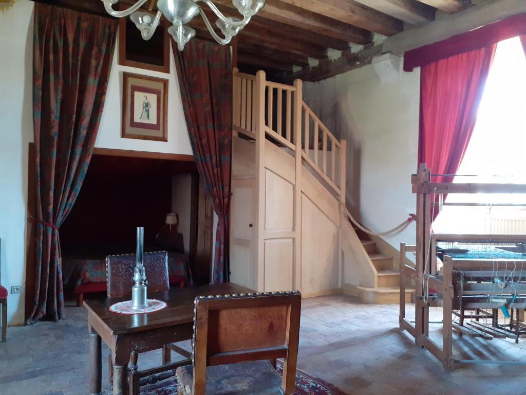 a living room with a staircase and a table at Chateau de Chémery in Chémery