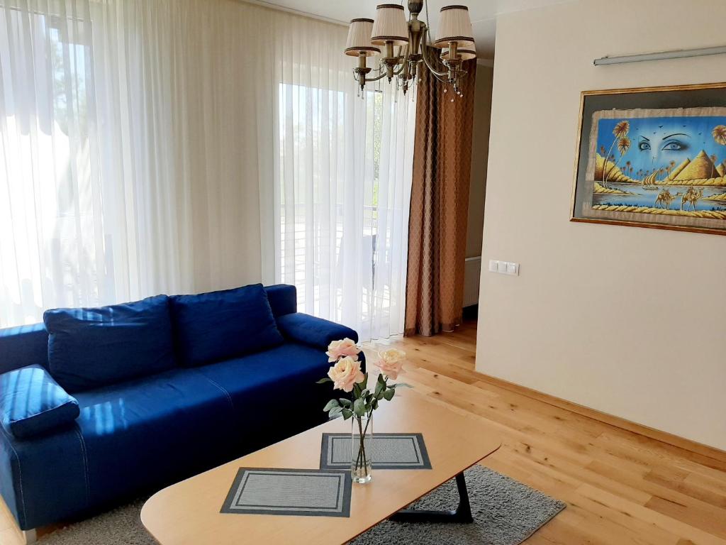 a living room with a blue couch and a table at Bangų gatvė 7 in Klaipėda