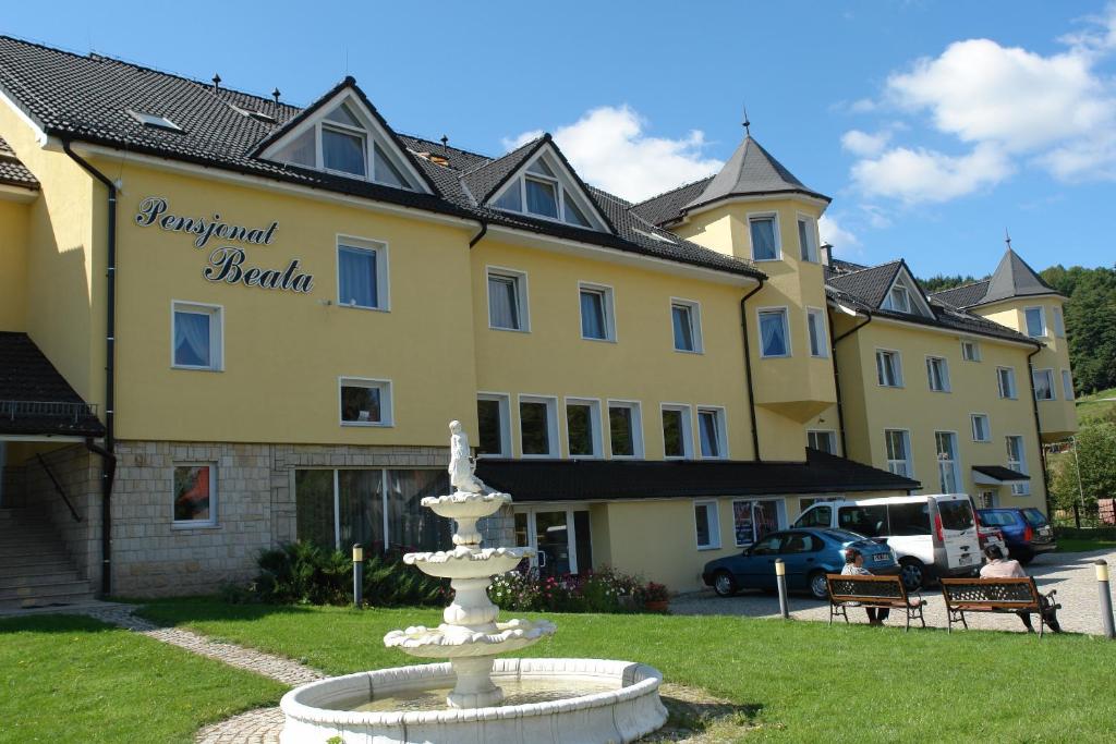 a building with a fountain in front of a building at Pensjonat Beata in Polanica-Zdrój