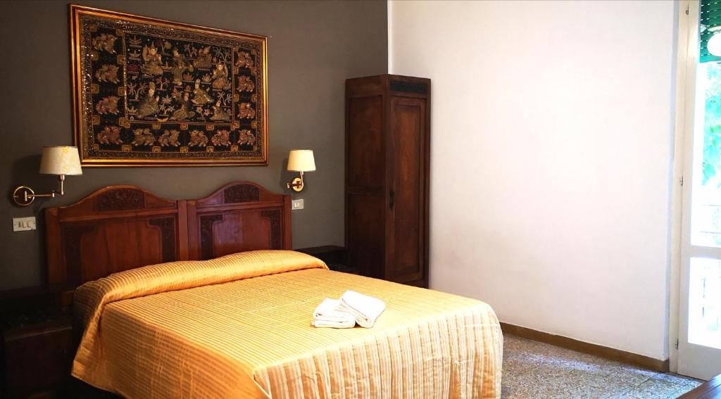 een slaapkamer met een bed met twee handdoeken erop bij VILLA ANTONIETTA in Cesenatico