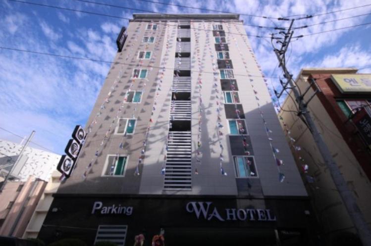 a tall building with a sign in front of it at WA Hotel in Busan