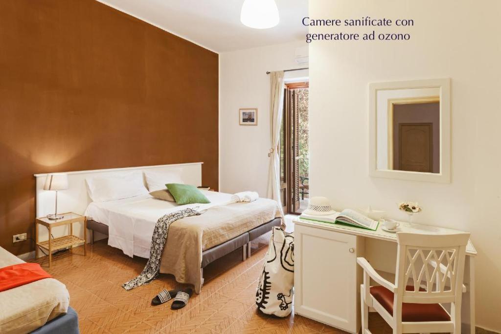 Un dormitorio con una cama y un escritorio y una cama. en B&B Viale dei Pini, en Castellaneta Marina