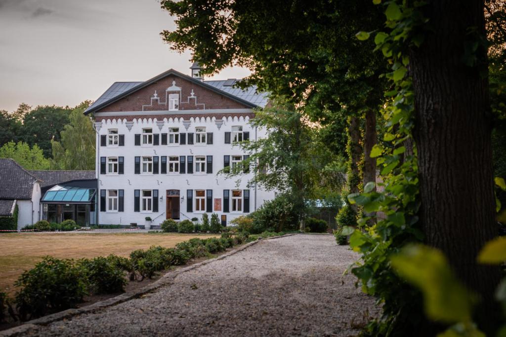 ein großes weißes Haus mit großer Auffahrt in der Unterkunft Fletcher Hotel Château De Raay in Baarlo