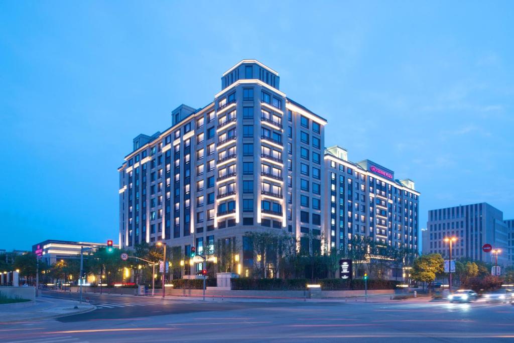 een hoog gebouw 's nachts met een straat ervoor bij Crowne Plaza Shanghai Pujiang, an IHG Hotel in Shanghai