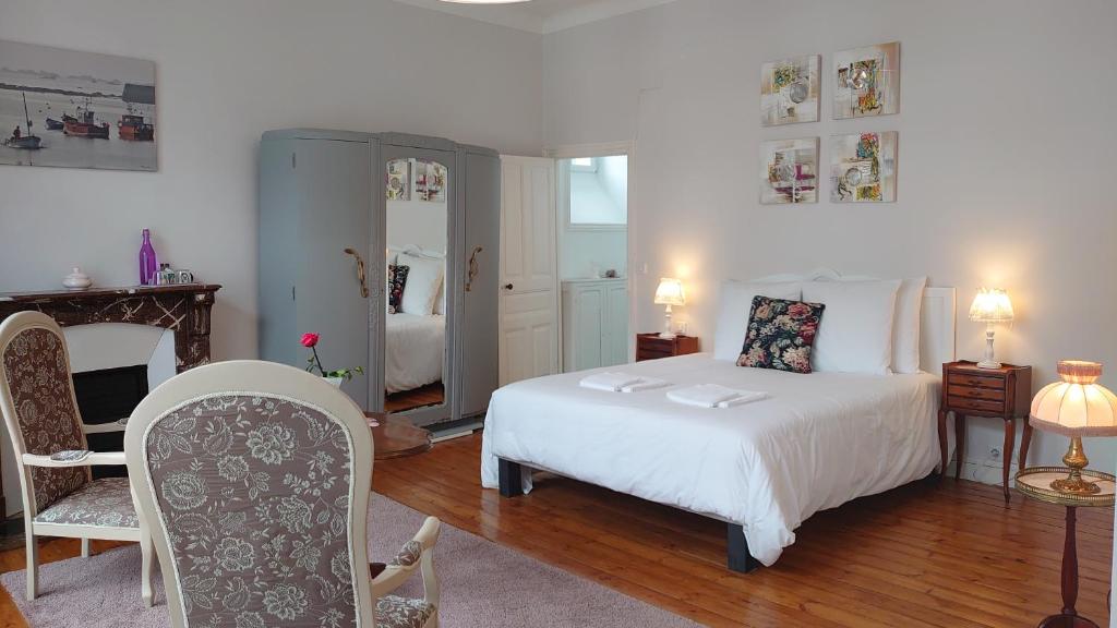 a bedroom with a white bed and a fireplace at La Maison Serrurier - Chambres d’hôtes in Morlaix