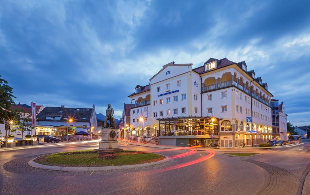 a building with a statue in the middle of a street at Luitpoldpark-Hotel in Füssen