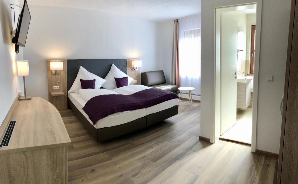 1 dormitorio con 1 cama extragrande y 1 silla en A Lotus Hotel, en Böblingen