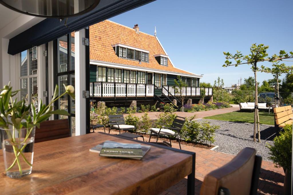 a patio with a table and chairs and a building at Saenliefde in Wormer