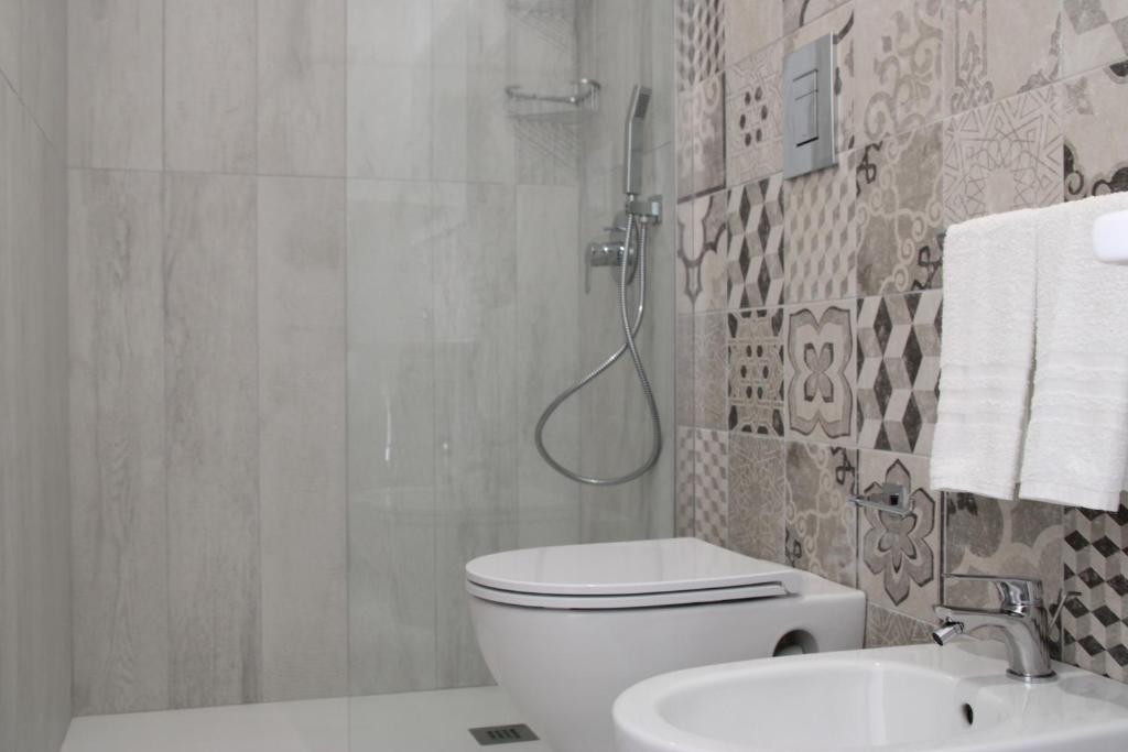 a bathroom with a shower and a toilet and a sink at La Guitgia Rooms in Lampedusa