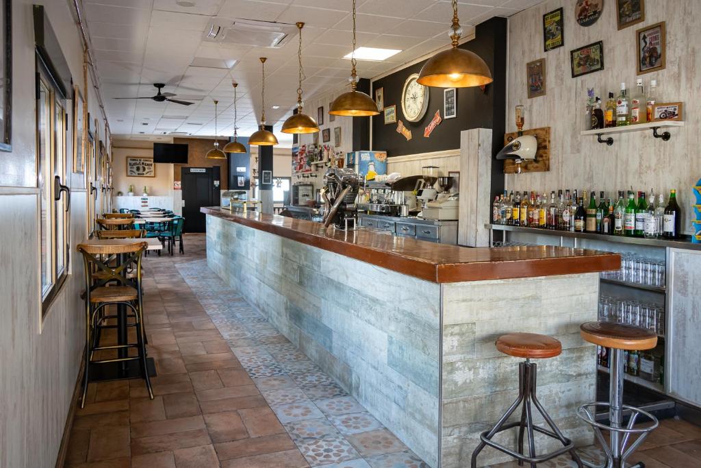 un bar en un restaurante con taburetes en Hostal El Trillero, en Alcañiz