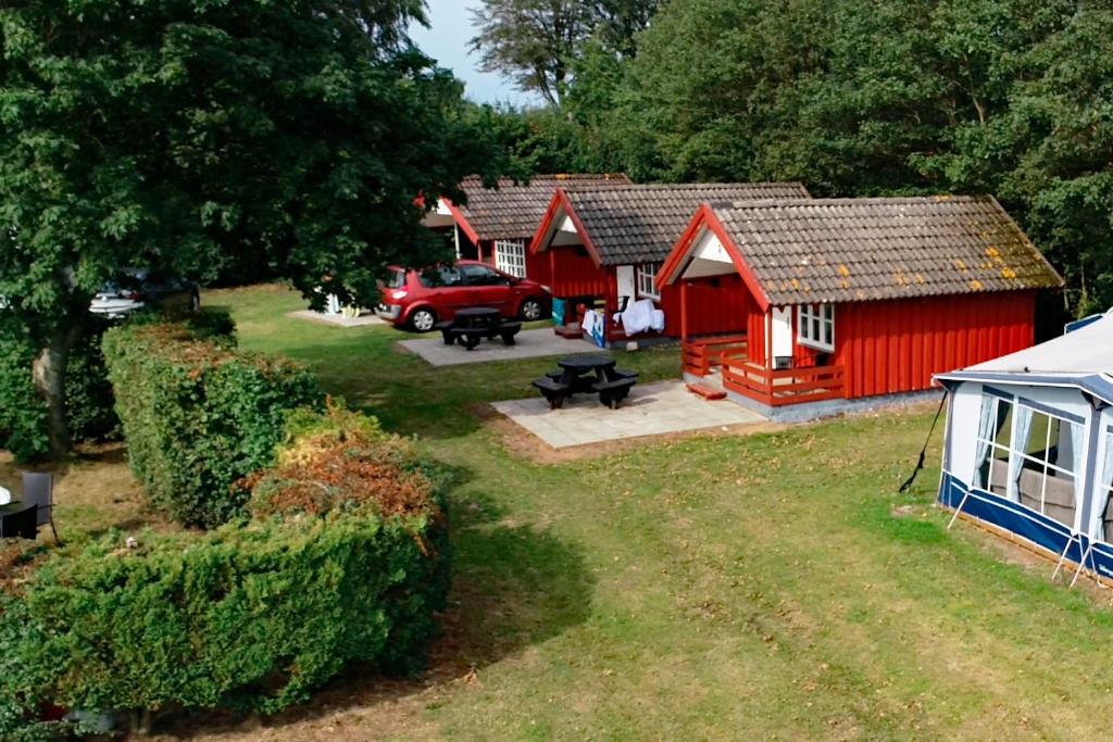an aerial view of a red barn and a white tent at Bredebro camping in Bredebro