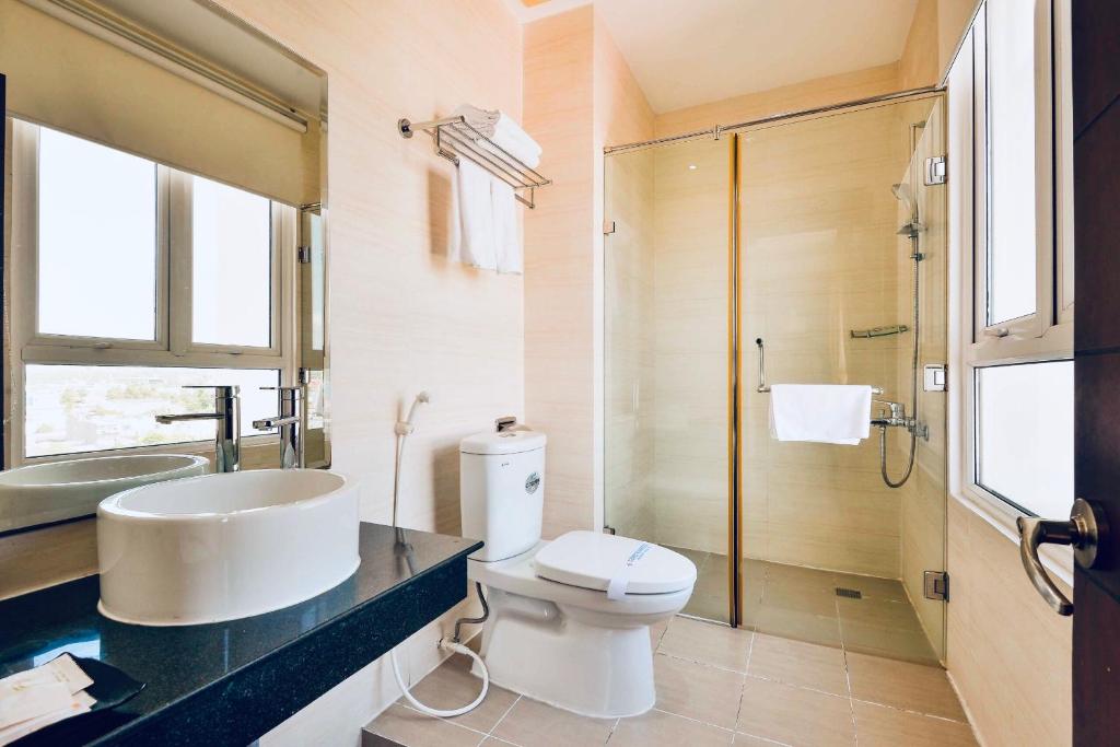 a bathroom with a sink and a toilet and a shower at Happy Life Hotel District 7 Gần SECC in Ho Chi Minh City
