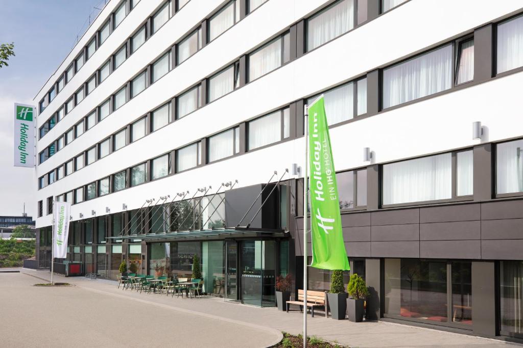 um edifício com uma bandeira verde em frente em Holiday Inn Munich - Leuchtenbergring, an IHG Hotel em Munique