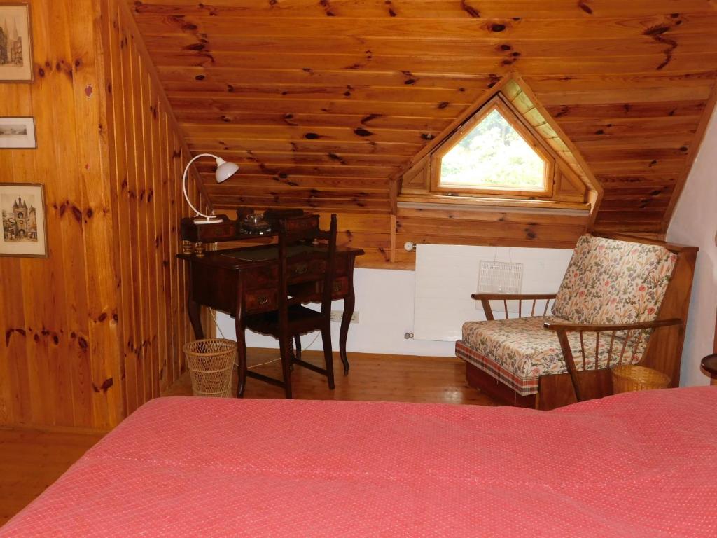 a bedroom with a desk and a table in a cabin at Ferienhaus Himmelreichmühle in Rettenberg