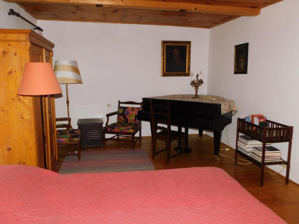 a living room with a table and chairs and a room with a piano at Ferienhaus Himmelreichmühle in Rettenberg