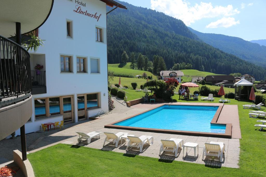 hotel z basenem obok budynku w obiekcie Hotel Lindnerhof w mieście San Lorenzo di Sebato