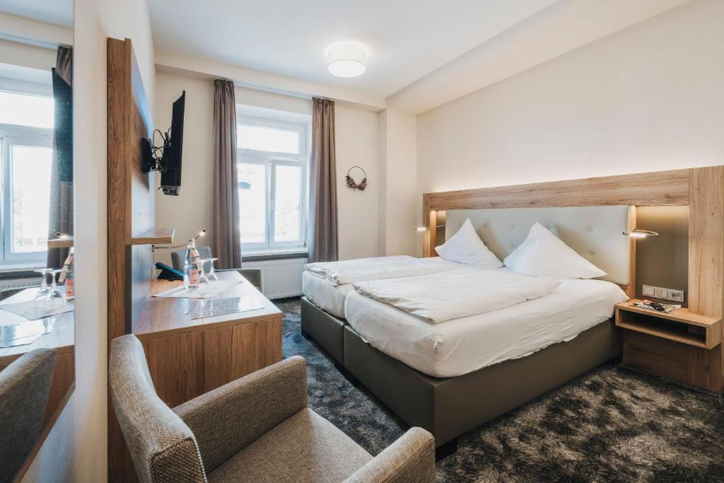 Habitación de hotel con cama y escritorio en Hotel Restaurant Roemer, en Merzig