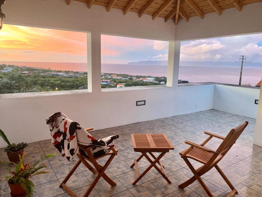 a room with two chairs and a table and windows at Casa do António Júlio in São Roque do Pico