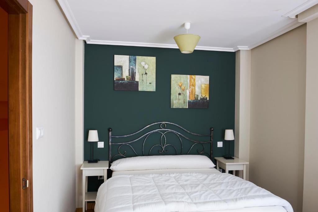 Schlafzimmer mit einem Bett mit blauer Wand in der Unterkunft San Pedro Villoria in Pola de Laviana
