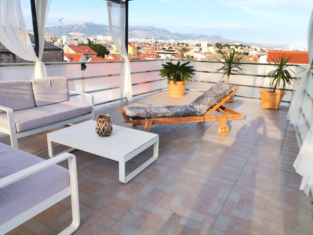 
a patio area with chairs, tables and umbrellas at Apartments Mariani in Split
