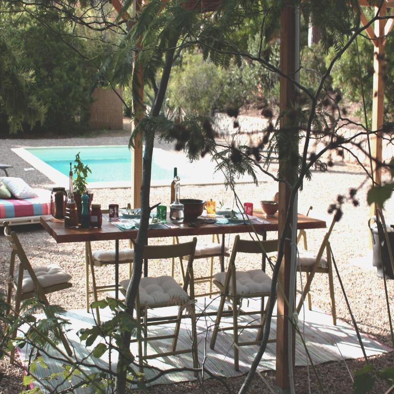 a wooden table and chairs in a yard with a pool at La Grechea Boutique B&B in Casa Alzi