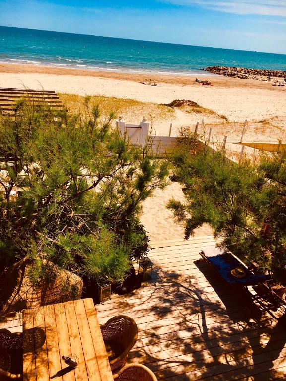 - une vue sur la plage avec une table de pique-nique et l'océan dans l'établissement Mas Andalou Fabuleuse première ligne de mer, plage privative, à Frontignan