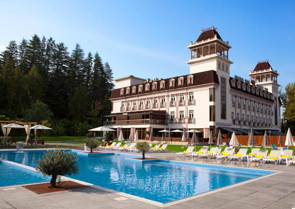 a hotel with a swimming pool in front of a building at Tskaltubo Plaza Hotel in Tskaltubo