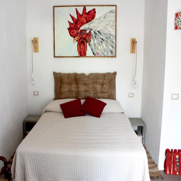 a bedroom with a white bed with red pillows at La Grechea Boutique B&B in Casa Alzi