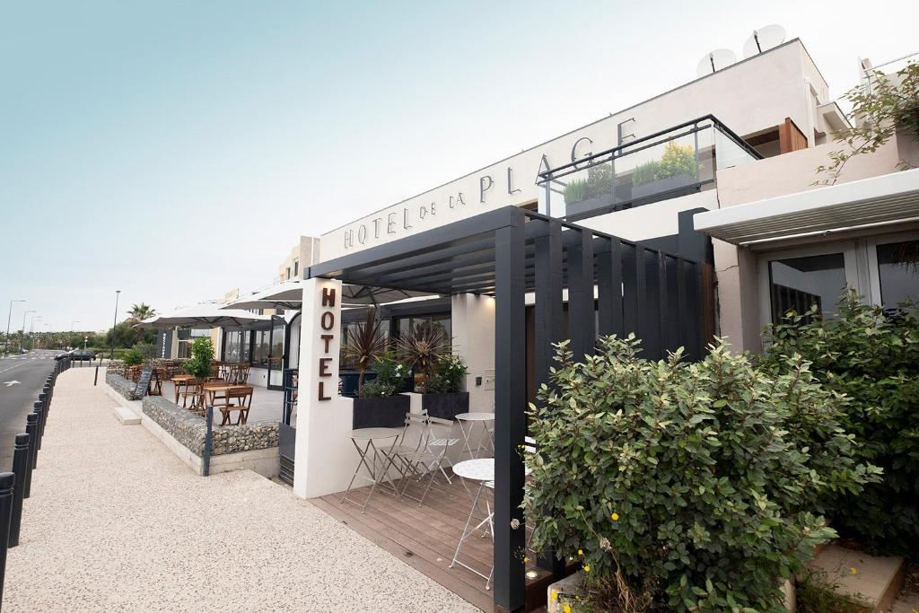 a building with a restaurant on the side of a street at Hôtel de la Plage in Sète