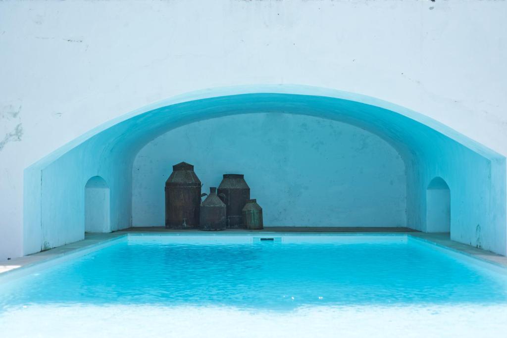 uma grande piscina com um arco no meio em Casa da Moira em Avis