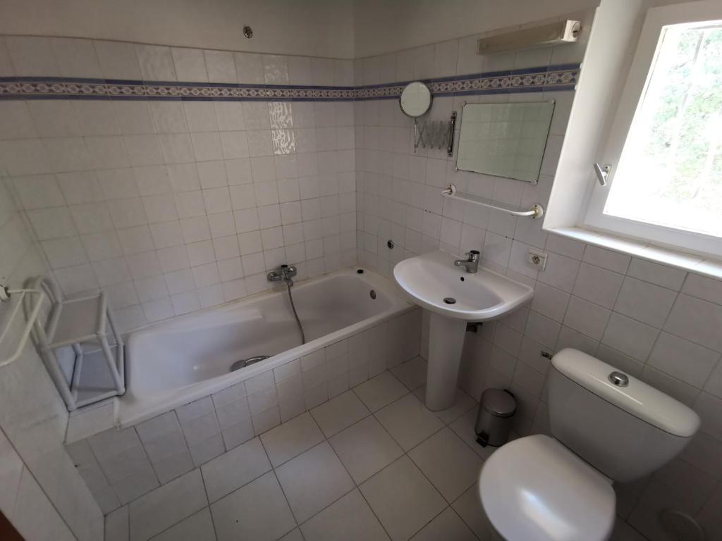 a bathroom with a tub and a sink and a toilet at mas cantarello in Rognes