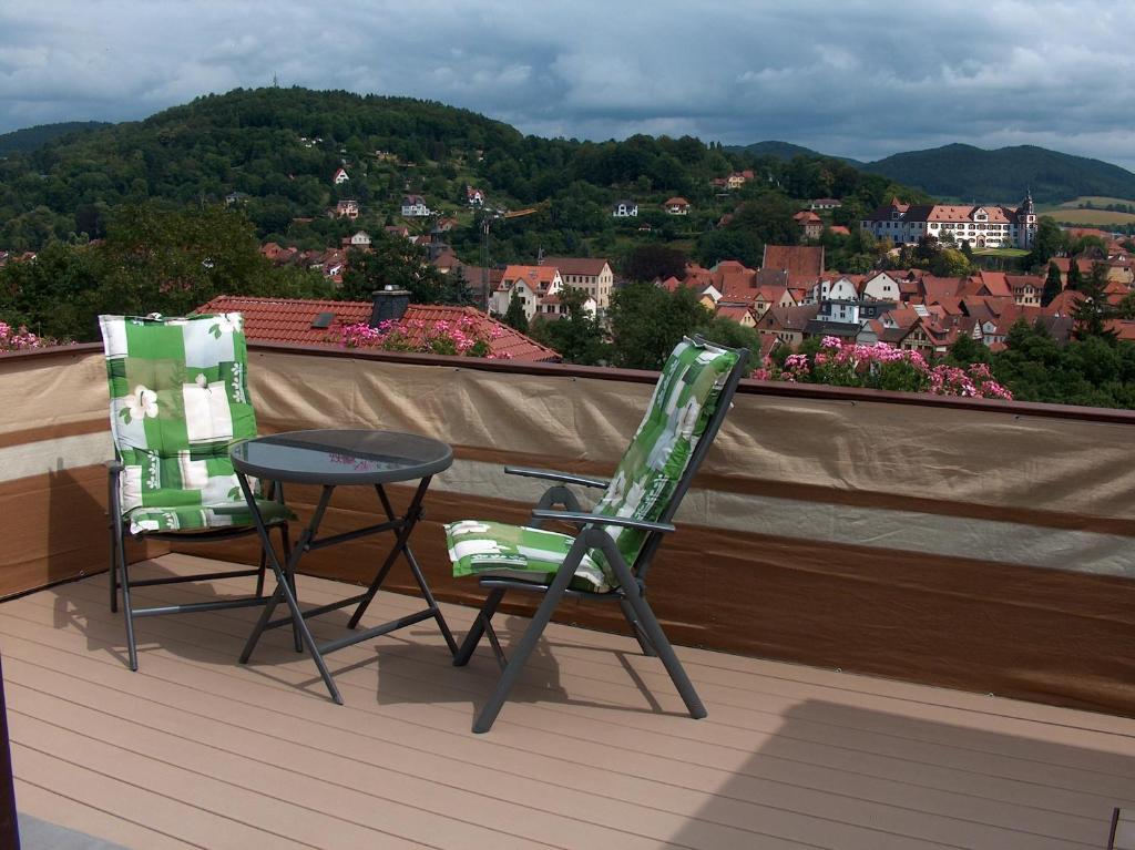2 Stühle und ein Tisch auf einem Balkon mit Aussicht in der Unterkunft Ferienwohnung Trollmann in Schmalkalden