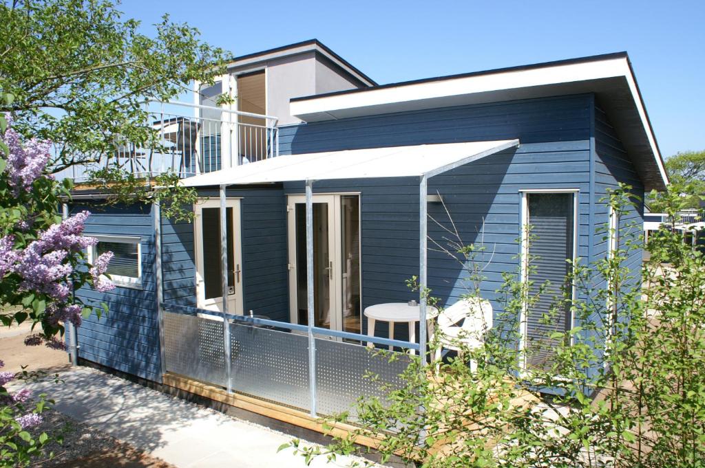 een blauw huis met een hek eromheen bij Fjordlyst Camping & Cottages in Aabenraa