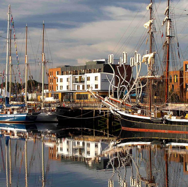 eine Gruppe von Booten, die in einem Hafen mit Gebäuden angedockt sind in der Unterkunft The Commissioners Quay Inn - The Inn Collection Group in Blythe