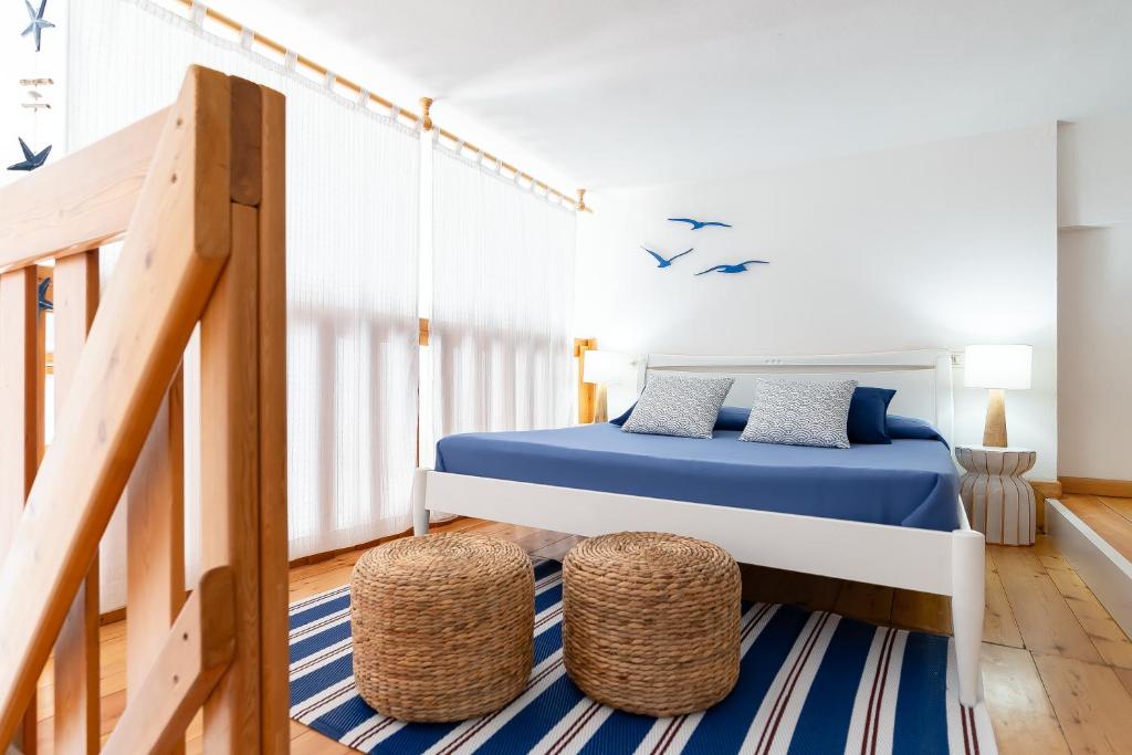 1 dormitorio con 1 cama y 2 taburetes en Casa Bolina, en Marina di Campo