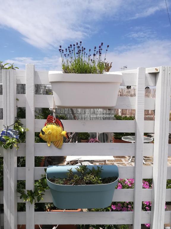 a white fence with a pot of plants on it at MandorleOlio in Polignano a Mare