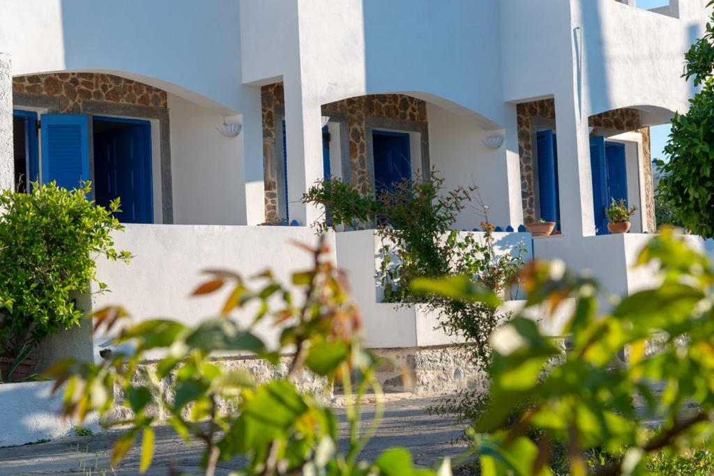 a row of white houses with blue windows at Milatos Studios in Milatos